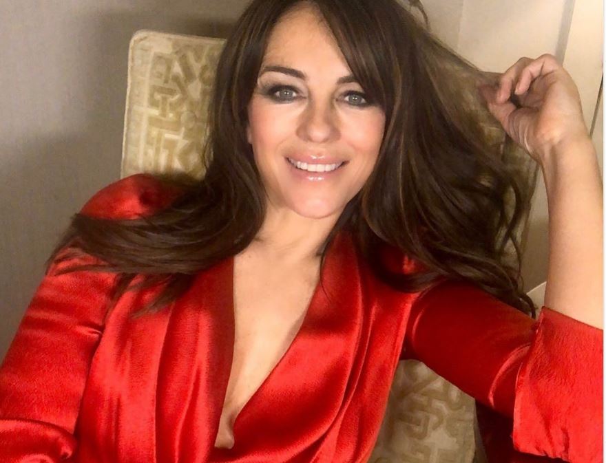 Elizabeth Hurley: Ποζάρει στο σαλόνι του σπιτιού της με ένα κόκκινο σατέν σεντόνι